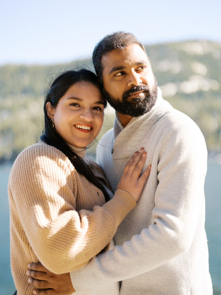 Close up of couples, the woman smiles and looks at the camera while the man looks at the horizon