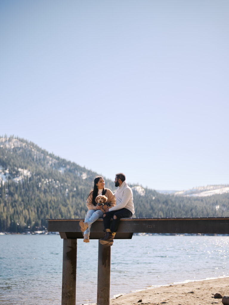 couple silling and holding dog in donner lake piers