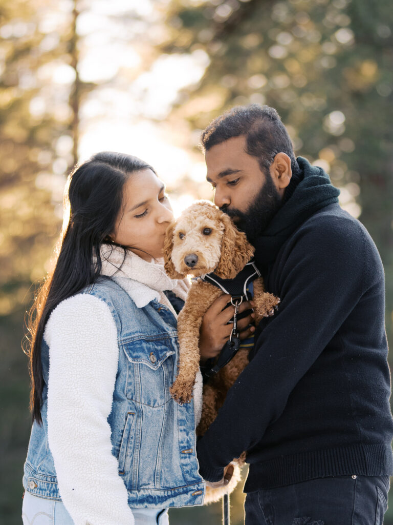 Couple kissing their dog at golder hour in donner lake