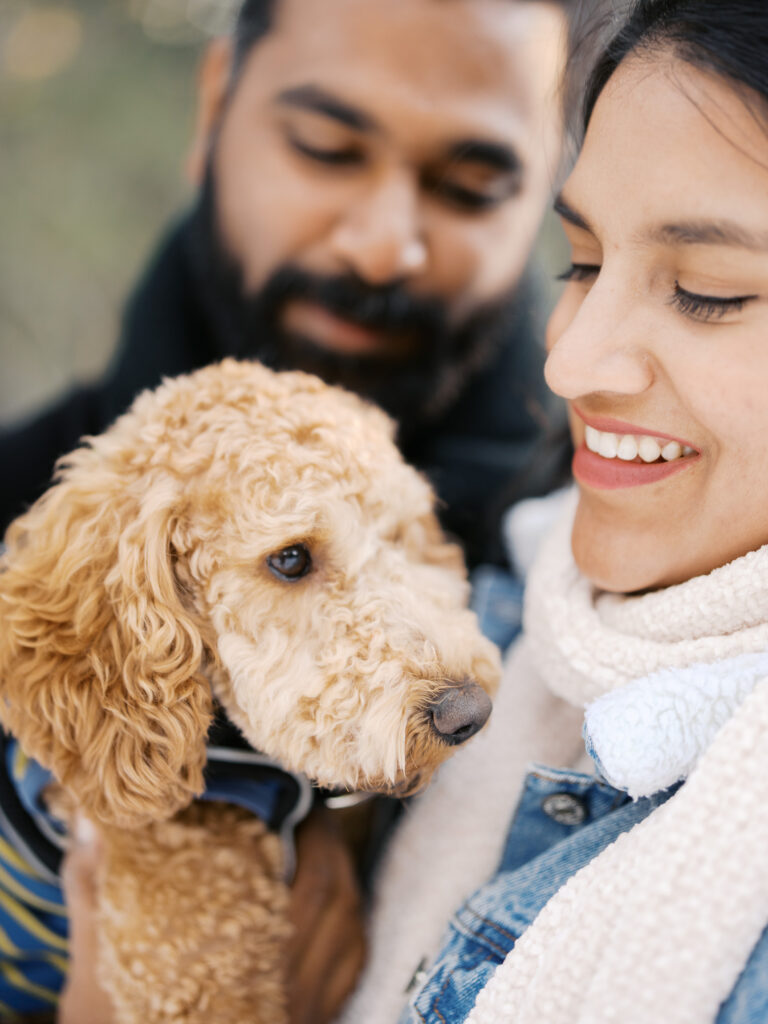 Close up of couple with their dog smiling at lake tahoe