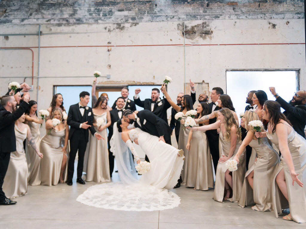 Bride and groom lifted by wedding party in industrial venue, Ybor City Tampa wedding celebration