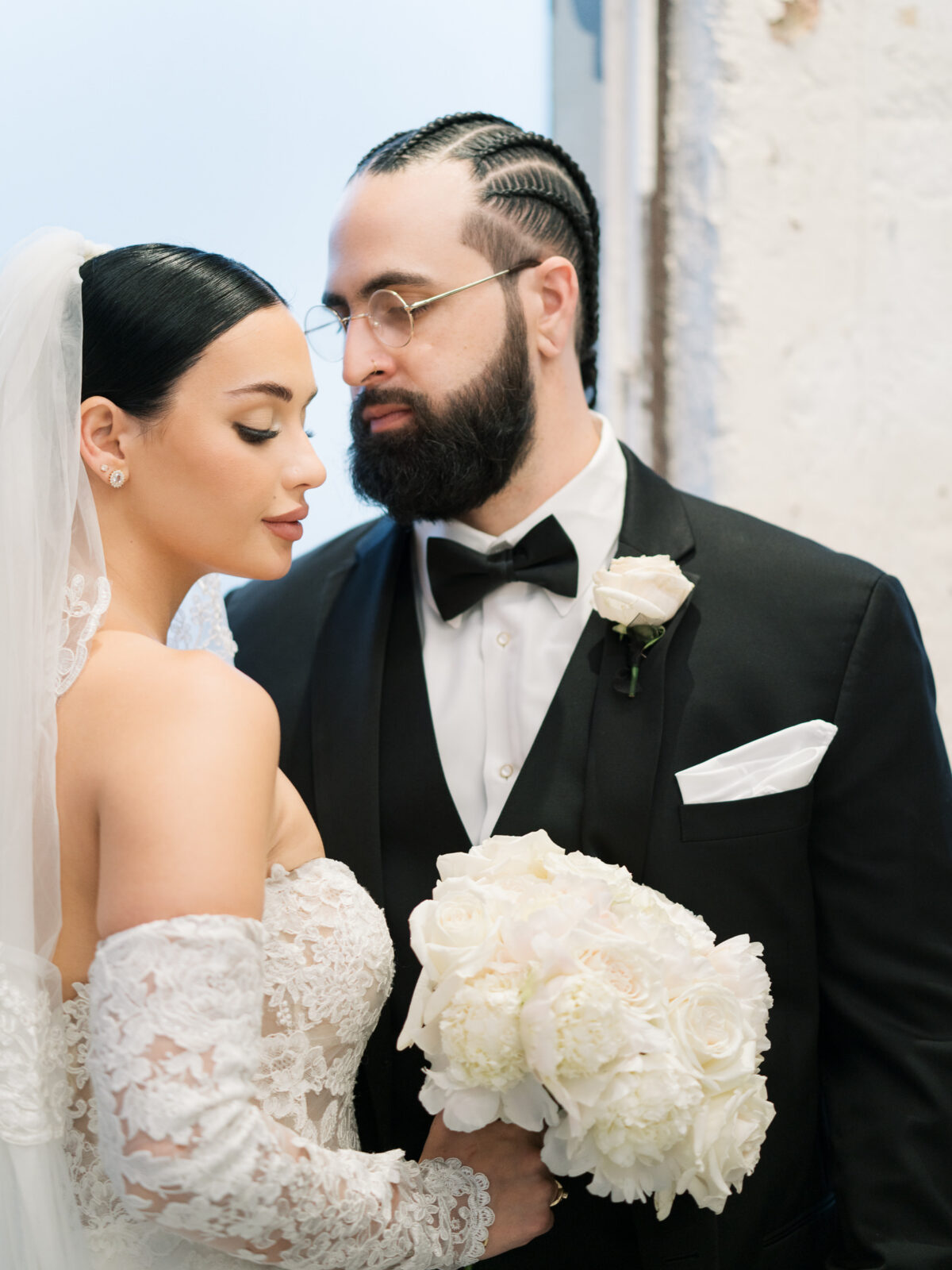 Bride and groom in intimate moment, lace off-shoulder gown and black tuxedo, Tampa destination wedding