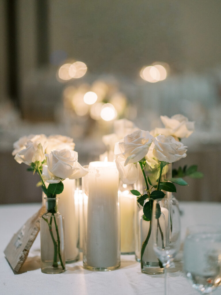 White floral centerpiece with candles in glass vases, Tampa wedding reception details