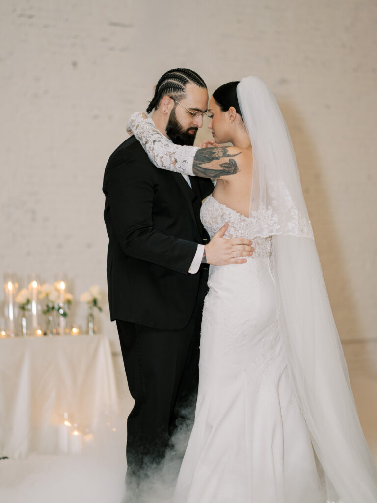 Bride and groom sharing first dance in candlelit reception venue, Tampa destination wedding photography