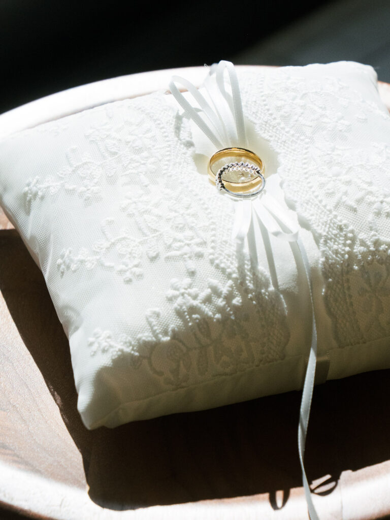Gold wedding rings on white lace ring pillow, Ybor City wedding details