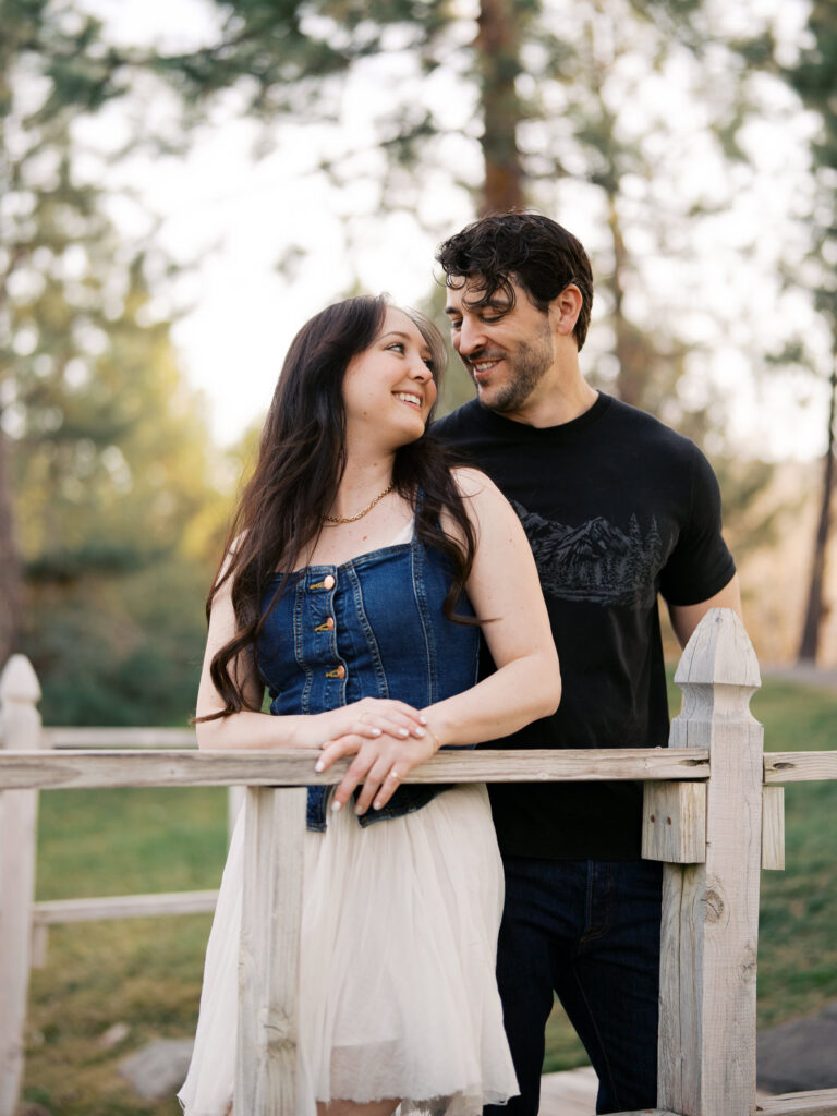 Close up photo of couple smiling at each other, her back leans agains his chest captured by a Reno photographer in a couples session