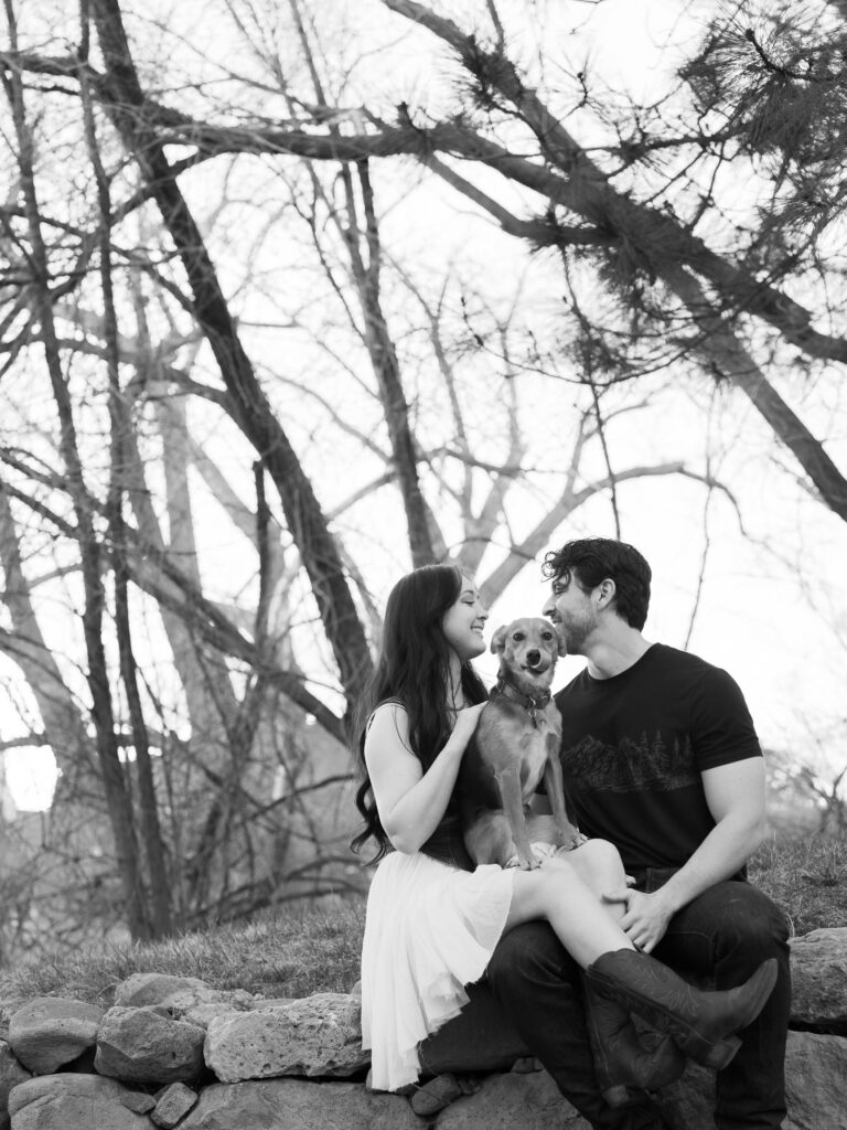 Couple sitting down in some rocks with ther dog captured by a Reno photographer in a couples session