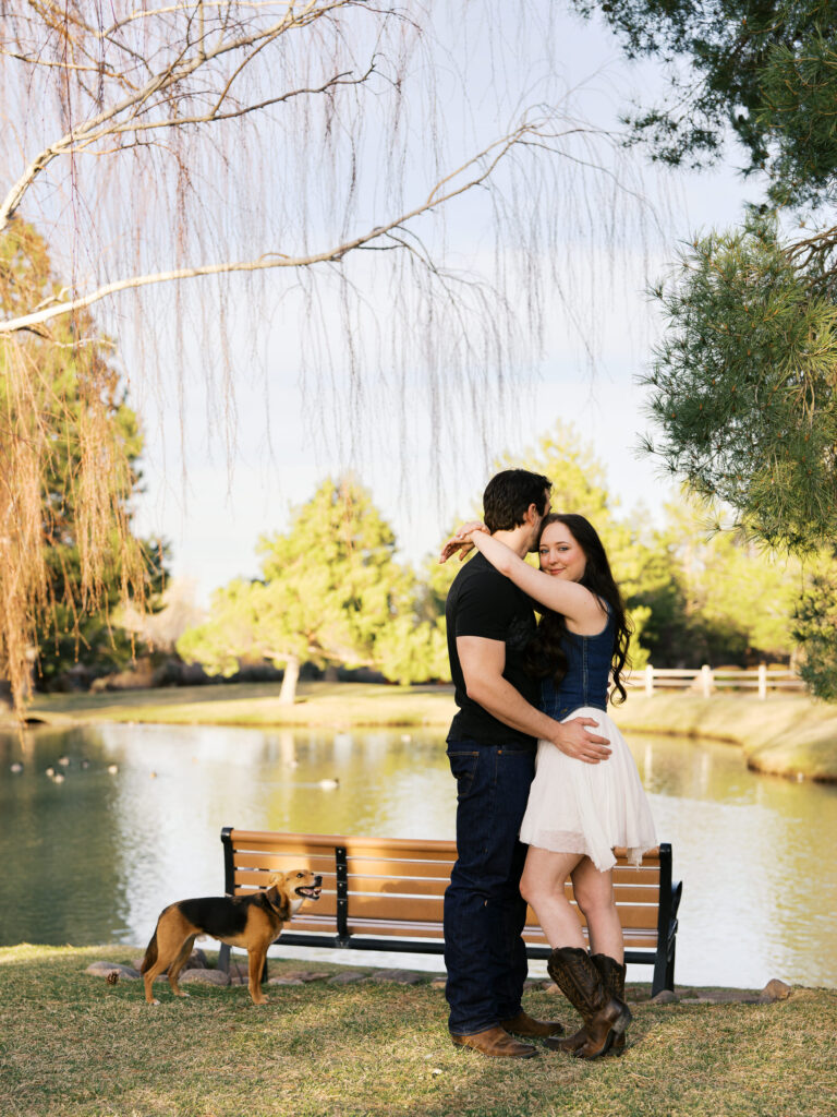 Couple where he looks away while she looks straights at the camera, their dog looks at them captured by a Reno photographer in a couples session
