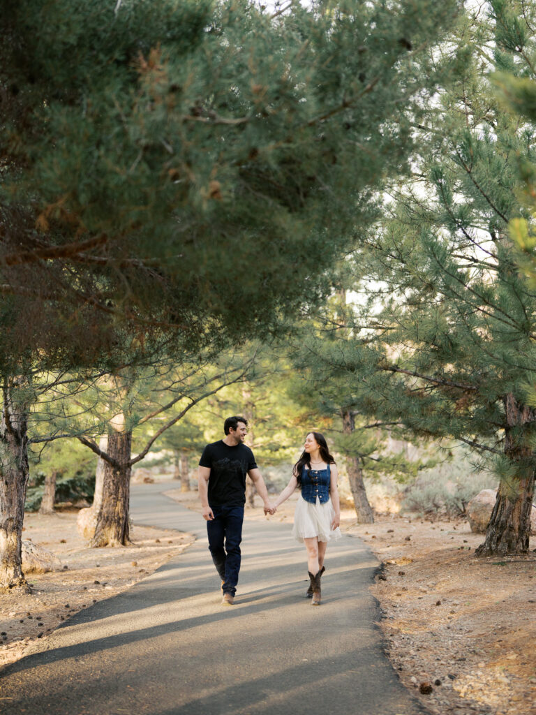 Couple walking facing each other in a park with trees captured by a Reno photographer in a couples session