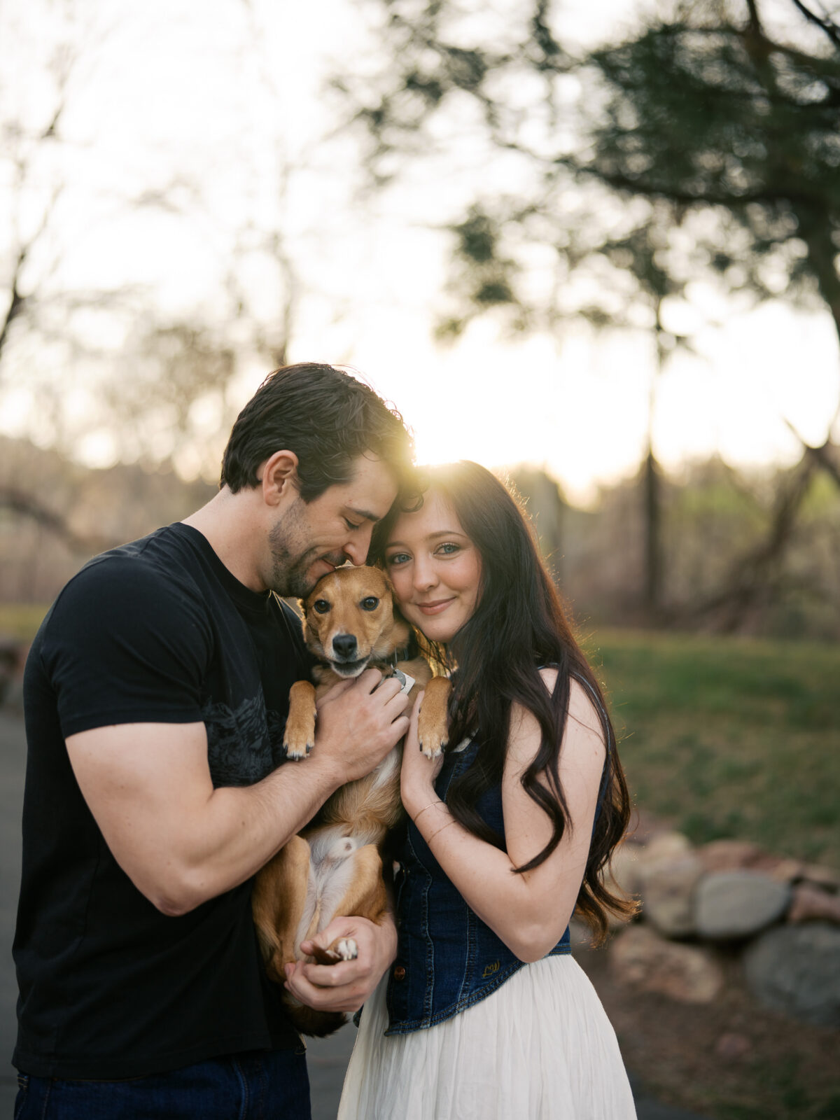 Close up portrait of a couple holding their dog at gplden hour captured by a Reno photographer in a couples session