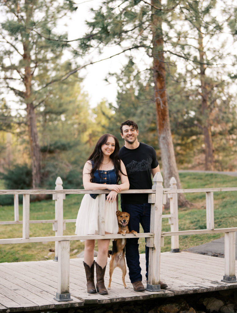 Couple standing in a small bridge with their dog captured by a Reno photographer in a couples session